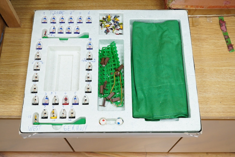 Two boxed Subbuteo table football sets; a European Edition, comprising of two teams, spectators and line side staff, pitch, etc. (some parts missing), and an International Edition, comprising of three teams, stadium ligh